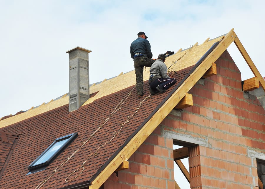 Roofers working near a ridge and skylight